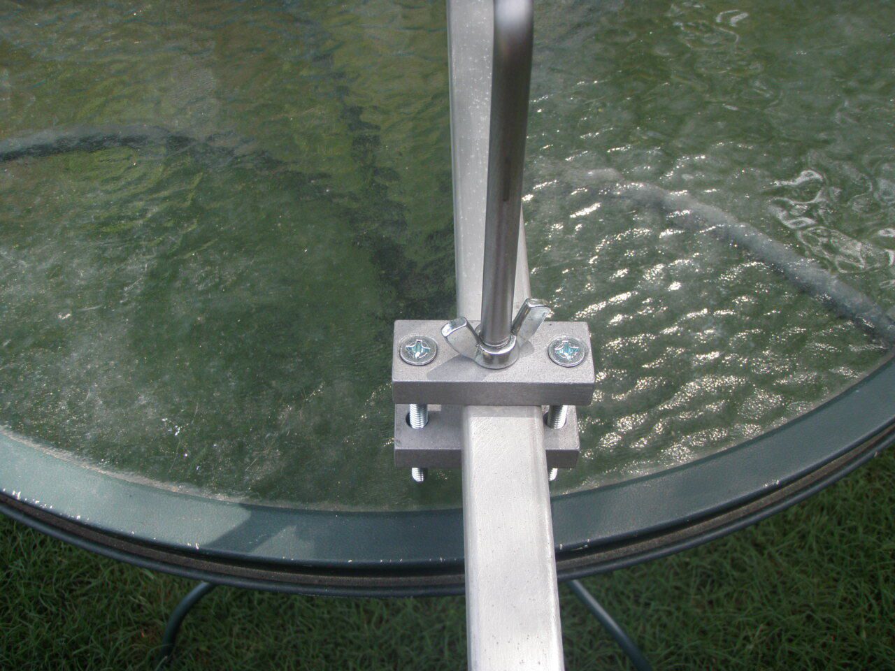 A glass table with a metal frame and some water