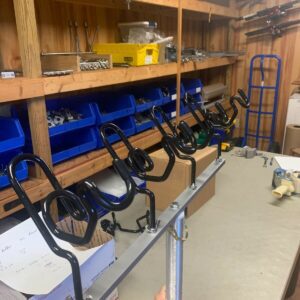 A room with many shelves and some tools hanging on it