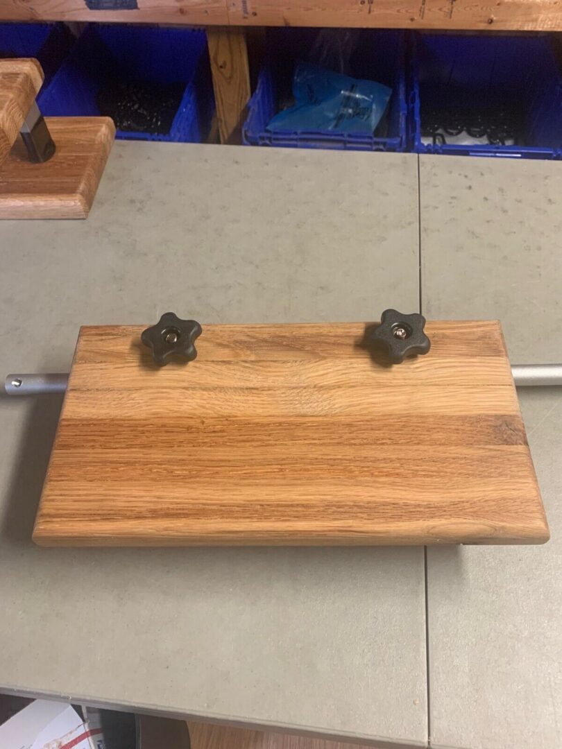 A wooden board with metal handles on top of it.