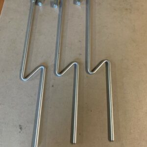 A set of three metal hooks on top of a table.