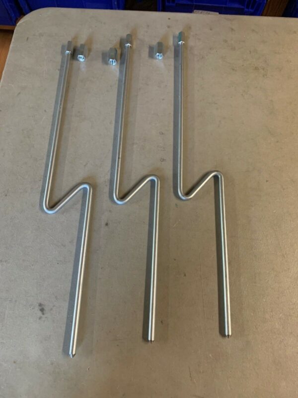 A set of three metal hooks on top of a table.