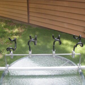 A glass table with four black metal handles.