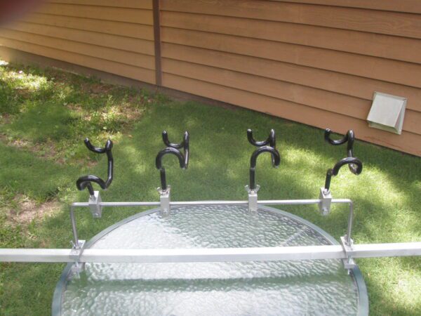 A glass table with four black metal handles.