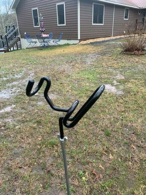 A black pole with two metal handles on it.