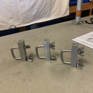 Three metal brackets are sitting on a table.