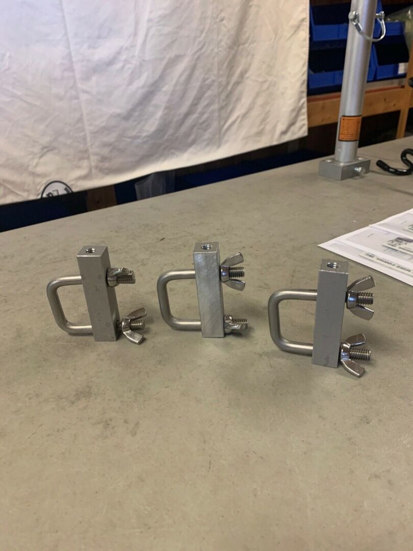 Three metal brackets are sitting on a table.