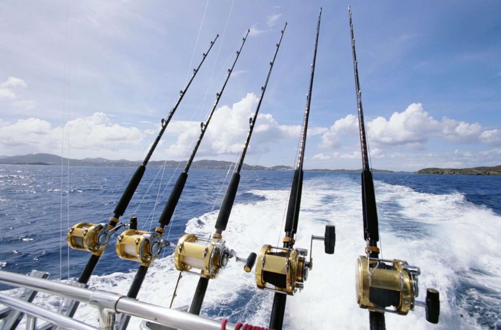 A group of fishing rods on the side of a boat.