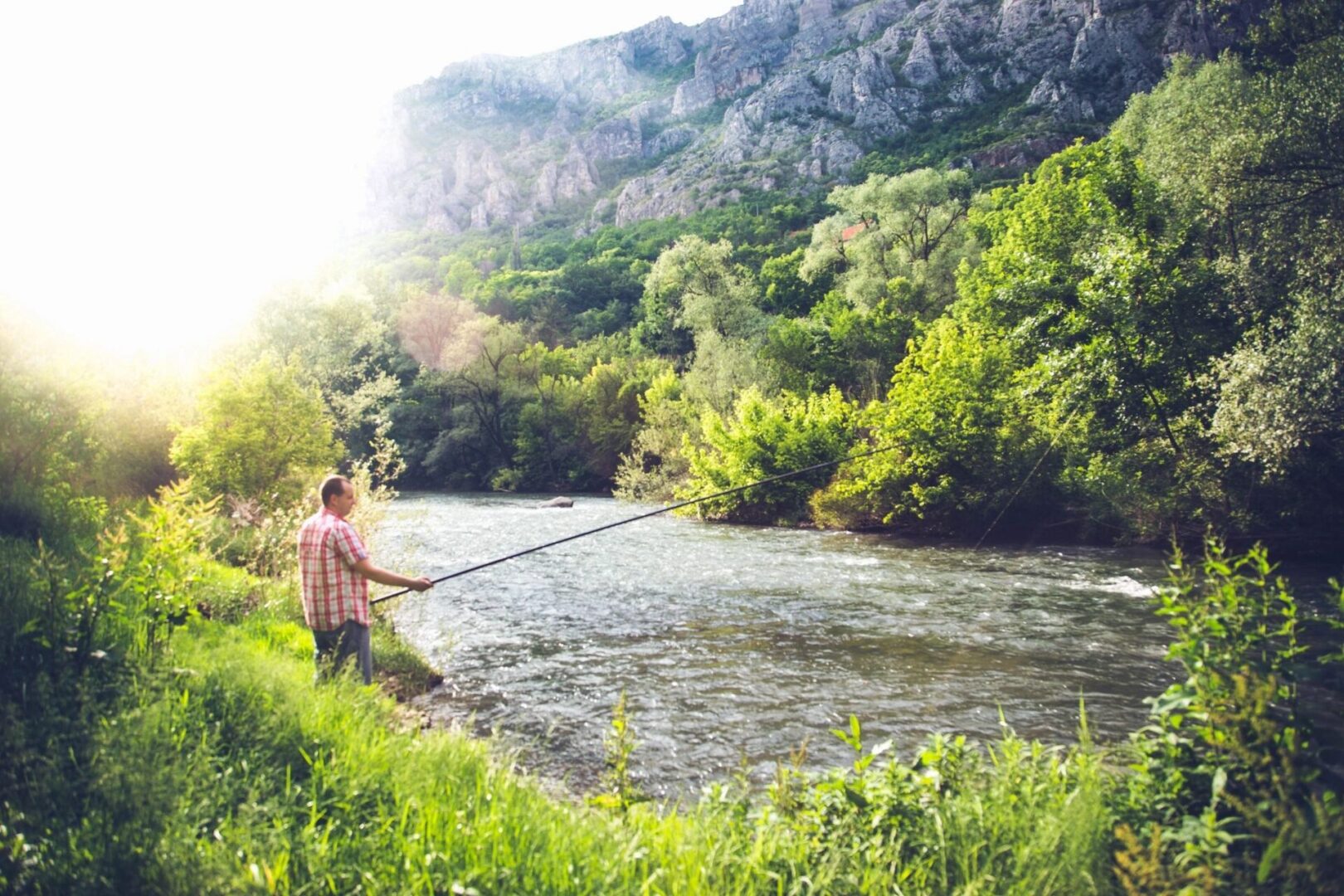 A man fishing in the middle of a river.