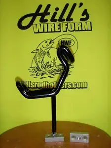 A black metal wire holder sitting on top of a yellow table.