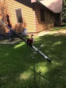A pole with a microphone in the middle of a yard.